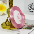 Roll of pink satin ribbon with gold stitched edges for gift wrapping and DIY crafts - Medium Pink