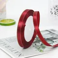 Dark red satin ribbon with gold edge detail on white spool for gift wrapping - Burgundy
