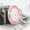 Pink satin ribbon with gold metallic edges on a roll for gift wrapping and DIY crafts - Pink
