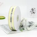 Creamy white 2.2cm organza ribbon with black Forever Love printing on a spool - FOREVER LOVE / Off White