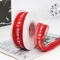 Red Christmas ribbon roll with white Merry Christmas text, reindeer and tree patterns - Red Organza Ribbon