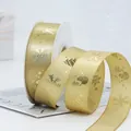 Champagne gold Christmas ribbon with snowflake and tree patterns on a white spool - Gold Snowman