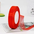 Red organza ribbon roll for gift wrapping and DIY crafts on a minimalist white desk - Red