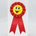 Red ribbon rosette badge featuring a cheerful yellow smiley face for party celebrations - Gilded Smiley Face Style / Red