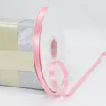 Pink satin polyester ribbon on white spool for gift wrapping and wedding decor - Pink