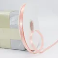 Roll of 1cm peach pink satin ribbon on a spool for elegant gift and cake wrapping - Champagne Pink