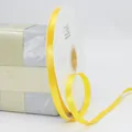 Roll of 10mm bright yellow satin ribbon used for elegant gift box packaging decoration - Light Golden Yellow