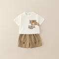 Sommerliches Jungen-Set mit cremefarbenem Comic-T-Shirt und Khaki-Shorts - 80 / Gebrochenes Weiß