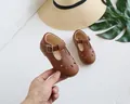Detail view of brown Mary Jane shoes with hollow cut-outs and scalloped edge trim - 16 / Brown