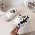 Breathable baby walking shoes in beige and black with dual hook-and-loop straps - Toddler Size Sixteen / Off White