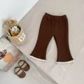 Detailed view of girls brown flared trousers with white lace trim and elastic waistband - Brown / 73cm