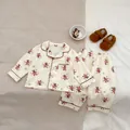Dettaglio pigiama neonato beige con stampa di orsetti e etichetta taglia 73 - Orso / 73