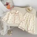 Detail of baby girl floral pajamas showing lace trim and soft cotton button-up top - 73cm / Floral