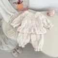 Détail du pyjama en polaire pour bébé avec col en dentelle blanche et ourlet volanté - Blanc / 73cm