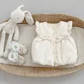 Detailed shot of cream quilted baby vest with ruffles, bows and lace infant shoes - Apricot / 73cm