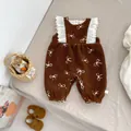 Detailed close-up of brown fleece baby romper with white bow prints and lace ruffles - 66 / Brown