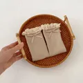 Close-up of beige ribbed knit baby socks with lace trim and delicate bow detail - One Size / Khaki