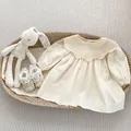 Détail de robe bébé fille en coton avec col en dentelle, broderie florale et chaussures - 80 / Robes