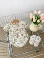 Detail of floral baby bodysuit with lace trim and matching shoes in a rustic setting - Floral / 66cm