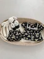 Flat lay of floral baby girl set with top, bloomers and shoes in a wicker basket - Black Floral Top And Pants / 73cm