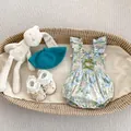 Détail d'un body floral pour bébé avec volants et nœuds en velours vert dans un panier - 80cm / Barboteuse