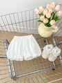 Close-up of white ruffled baby bloomer shorts and lace princess shoes in a metal cart - White / 66cm