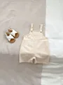 Close-up of cotton linen baby romper showing shoulder buttons and front pocket detail - 66CM / Apricot