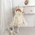 Infant cream floral romper dress with tulle bow and embroidery on a wooden hanger - 66cm / Apricot