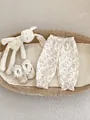 Detail view of floral cotton baby pants with ruffle cuffs in a rustic basket - 73 / Bottoms / Rice Purple Floral