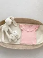 Detail of pink ribbed baby shirt with ruffle collar and butterfly sleeves in a basket - 66 / Pink
