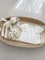 Flachbild von Baumwoll-Babytop mit Rüschen und Schnürschuhen im Weidenkorb - Weiß / 66CM