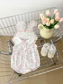 Dettaglio della tutina neonato con stampa tulipani e scarpe con pizzo nel carrello - 66 / Rosa