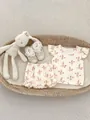 Flachbild von Baby-Sommeroutfit mit Hasenprints und Rüschenshorts in einem Weidenkorb - Größe 66 / Pilz Hase Stil