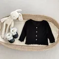 Detail van zwart gebreid vestje voor baby's met ruches en bijpassende schoentjes - 66 / Zwart