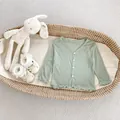Detail van baby zonnebeschermend vestje met geribbelde stof en ruches randen - 66 / Groen