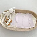 Dettaglio del cardigan rosa neonato in morbida maglia a coste con quattro bottoni bianchi - 66 / Viola
