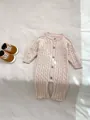 Detailaufnahme von beigem Baby-Strickstrampler mit Zopfmustern und hölzernen Knöpfen - 80cm / Set / Hellkaffee