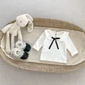 Detail der weißen Baby-Baumwollbluse mit Peter-Pan-Kragen und schwarzer Samtschleife - 73cm / Schwarzes Oberteil