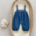 Detail of baby denim romper featuring white leaf embroidery and bottom snap buttons - Size 66 / Denim Blue Overalls