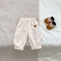 Close-up of baby bear embroidered cotton trousers with elastic waist and rolled cuffs - Casual Pants / Apricot / 66