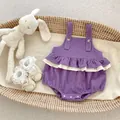 Close-up of purple corduroy baby bodysuit with floral ruffles and wooden buttons - 66 / Purple