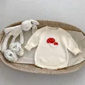 Dettaglio di pagliaccetto in maglia con funghi e scarpe in pizzo per neonati - 66CM / Albicocca