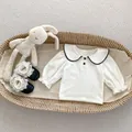 Detailed view of cream baby girl long-sleeve top with doll collar and ruffled cuffs - 66cm / White Blouse Set