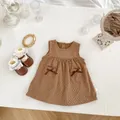 Flachbildaufnahme eines braunen gepunkteten Kleinkindkleides mit Schleifen auf Waffelstruktur - Größe 73 / Braun Punktmuster Trägerkleid