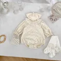 Flat lay of baby floral romper with ruffle lace collar, beret, wing socks and pearl bag - 66cm / Apricot (Include Hat Socks)