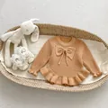 Detalle del tejido de punto de un suéter para bebé con lazo y bordes de volantes - 66 / Camel