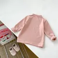 Détail d'un t-shirt thermique rose doux pour bébé avec tissu douillet et poignets roulés - 66CM / Rose