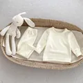 Soft cream thermal fleece baby pajamas set in a cozy woven basket with plush toy - 66 / White