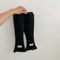 Close-up of ribbed knit pants hem featuring white mesh bow and slit detailing for girls - 66 / Black