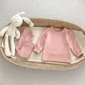 Detailed view of baby thermal innerwear set in soft bean paste pink on a cozy cradle - 66 / Pink